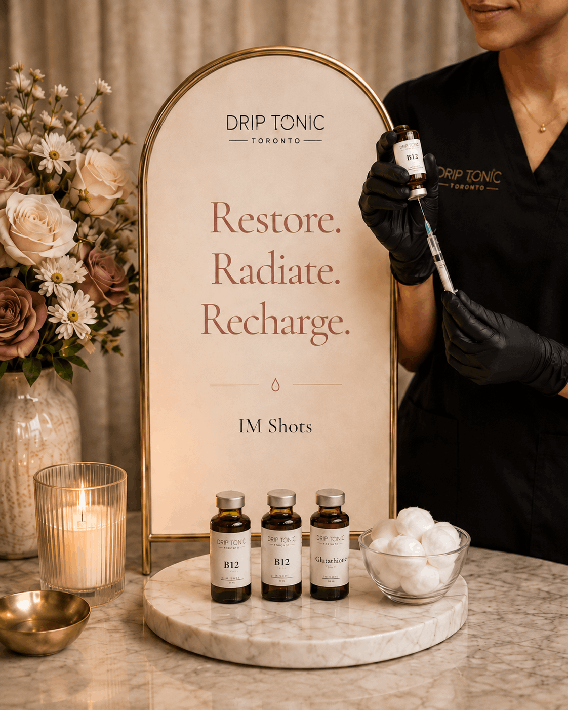 An RN at a Drip Tonic IM shot station — arched sign reading Restore, Radiate, Recharge with B12 and Glutathione vials on a marble tray.