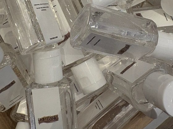 Drip Tonic's branded hand-sanitizer favours stacked at the wedding show booth, ready to fold into the giveaway bags.